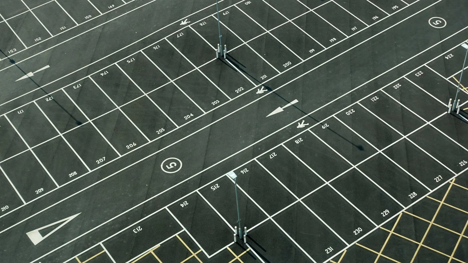 Aerial view of a numbered parking lot with painted directional arrows