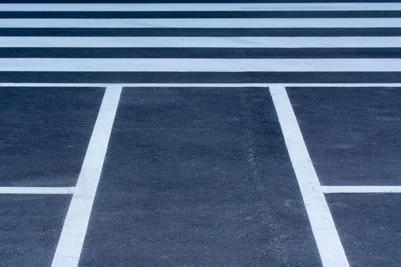 Ground-level view of fresh white crosswalk and parking stall lines